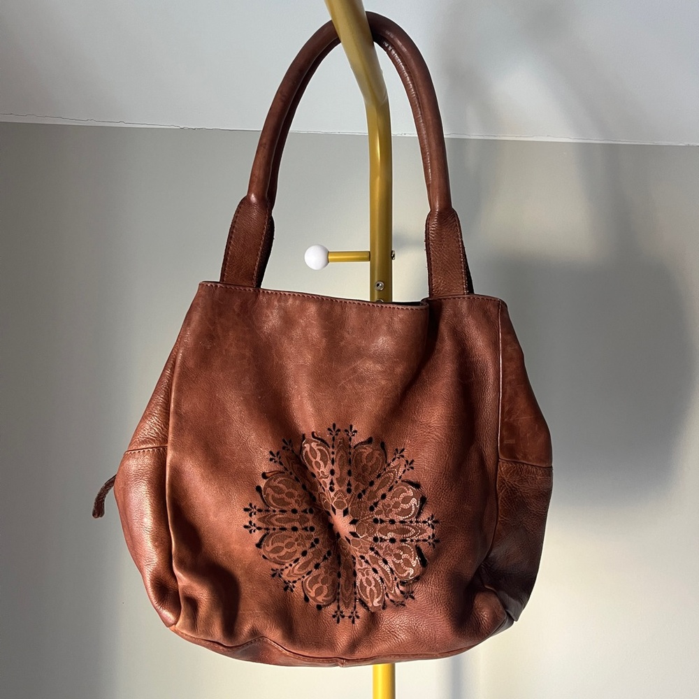 100% Leather brown slouchy top-handle shoulder bag with a mandala cutout design
